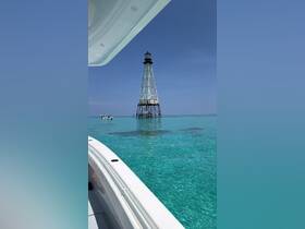 A stunning view of a lighthouse standing tall in the turquoise waters, captured from a boat — a perfect representation of coastal beauty and adventure.