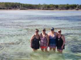 A group of friends enjoys a sunny day in shallow waters, creating unforgettable memories at the beach — perfect for a fun getaway.