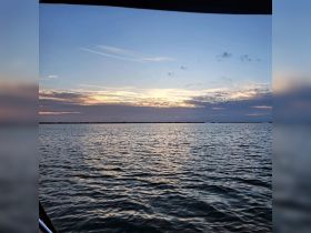 A serene view of the water at sunset, showcasing the tranquil beauty of the evening sky — perfect for peaceful boat rides and sunset cruises.