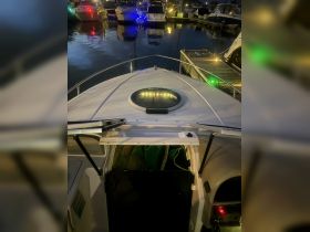 A view of the helm area inside a boat, showcasing the sleek design and ambient lighting at night — perfect for evening cruises.