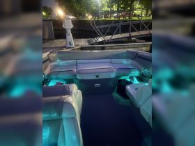 Interior view of a boat's seating area, featuring illuminated accents and a cozy layout, perfect for relaxing on the water.