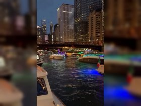 A vibrant night scene showcasing illuminated boats cruising along a bustling waterway in the city, perfect for evening boat tours and urban adventures.