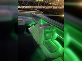Interior view of a stylish boat seating area, featuring modern design and ambient green lighting, perfect for relaxing on the water.