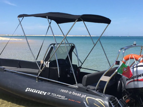 A sleek Pioneer 17 Touring speedboat docked in shallow waters, showcasing its modern design and perfect for rental adventures on the coast.