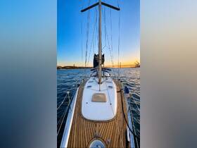 A stunning view of a sailboat's deck, showcasing its elegant design against a backdrop of a sunset and distant landmarks, perfect for sailing enthusiasts.