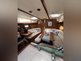 Interior view of a cozy boat cabin featuring comfortable seating and a dining area, perfect for relaxing and enjoying meals while at sea.