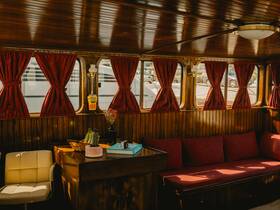 A cozy interior view of a boat's cabin featuring comfortable seating and warm wooden accents, perfect for relaxing while on the water.