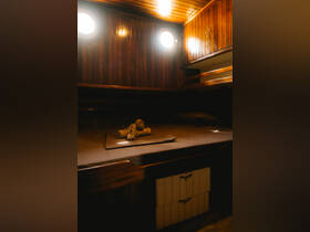 A cozy cabin interior of a boat featuring wooden paneling and neatly arranged towels, perfect for relaxation on the water.