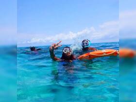 Two snorkelers enjoy a vibrant underwater adventure, showcasing the excitement of swimming in crystal-clear waters — perfect for group outings and marine exploration.