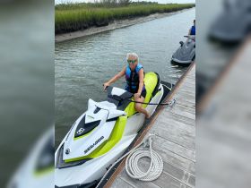 A woman enjoys riding a jet ski in a scenic waterway, showcasing the thrill of outdoor water activities.