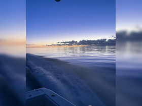 A serene sunset view from a boat, showcasing calm waters and a beautiful sky — perfect for evening cruises and relaxation on the water.