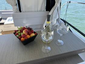 A beautifully arranged fruit platter and wine await guests on a boat, perfect for a relaxing day on the water.