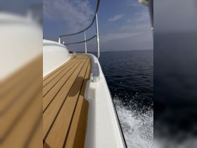 A close-up view of the deck of a boat, showcasing the polished wood and sleek design as it cuts through the water, perfect for showcasing vessel aesthetics.
