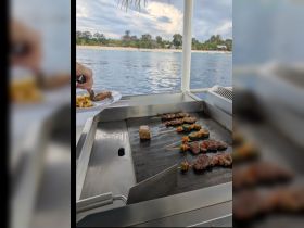 Delicious skewers and grilled meats are prepared on a boat, showcasing the perfect amenities for a memorable dining experience on the water.