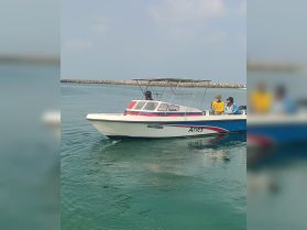 A group enjoys a ride on the boat 'Aries' as it glides through clear waters, showcasing a perfect day for boating adventures.