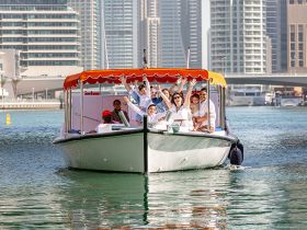 A joyful group celebrates aboard a boat in a vibrant city setting, showcasing the perfect blend of fun and urban adventure on the water.