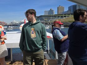 A group of friends enjoys a sunny day on a boat, capturing the essence of a fun outing on the water with stunning views of the harbor.