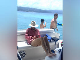 A relaxing moment on a boat with family, featuring a woman on her phone and a boy enjoying the water — perfect for summer adventures and family outings.