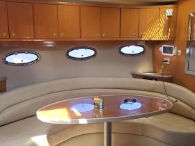 Interior view of a cozy boat cabin featuring comfortable seating and ample storage, perfect for relaxing during a day on the water.