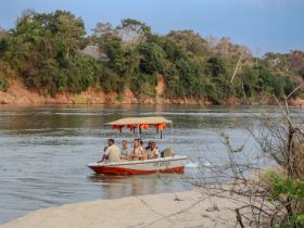 A group of friends enjoys a scenic boat ride on the river, surrounded by lush greenery — perfect for adventure and exploration.