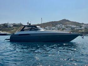 A sleek yacht docked in clear waters, showcasing its elegant design against a picturesque coastal backdrop.