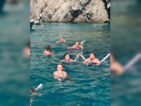A lively group enjoys swimming in crystal-clear waters, showcasing the fun and excitement of a snorkeling adventure.