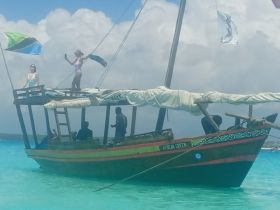 A lively scene aboard the 'African Queen' with guests enjoying the sun and water, showcasing the vibrant atmosphere of a tropical adventure.