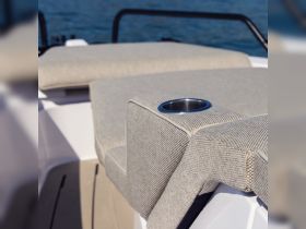 A close-up view of stylish seating with a built-in cup holder on a boat, showcasing the comfort and design features ideal for relaxing on the water.