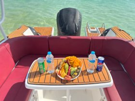 A beautifully arranged platter of fresh fruit and drinks on a boat, perfect for enjoying a relaxing day on the water.