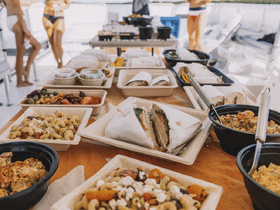 A delicious spread of catered food on a boat, featuring a variety of snacks and lunch options, perfect for enjoying while cruising on the water.