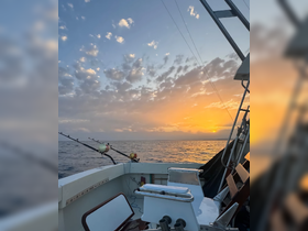 A serene view from the helm of a fishing boat at sunset, showcasing the tranquil ocean and colorful sky — perfect for fishing enthusiasts and sunset lovers.
