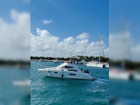 A lively scene aboard a yacht with guests enjoying their time on the water, showcasing the perfect atmosphere for a day of fun and relaxation.