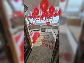 A beautifully decorated interior of a boat featuring romantic elements like balloons and rose petals, perfect for special occasions or intimate celebrations.