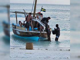 A lively group arrives at the beach from a traditional boat, showcasing the excitement of beach adventures and water activities.