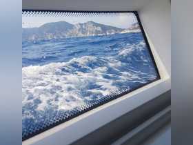 A view from inside a boat looking out at the ocean and distant mountains, but the focus is unclear.