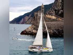 A picturesque sailing scene featuring a yacht navigating near a stunning coastal historic site, showcasing the beauty of the landscape and the joy of sailing.