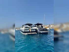 A stunning view of two luxurious yachts anchored in clear turquoise waters, showcasing their sleek designs against a picturesque backdrop.