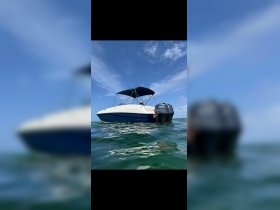 A sleek speedboat with a Yamaha engine glides through clear waters under a bright blue sky, perfect for summer adventures on the water.
