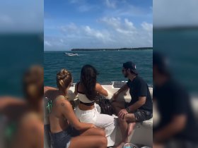 A group of friends enjoys a day on the water, taking in the beautiful scenery as another boat speeds by. Perfect for memorable outings and adventures on the sea.