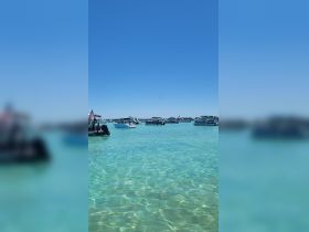 A picturesque view of multiple boats anchored in crystal-clear turquoise waters, perfect for a day of relaxation and fun on the water.