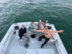 A cheerful group of friends enjoys their time aboard a boat, capturing a moment of fun and camaraderie on the water.