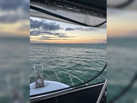 A serene view from the front of a yacht, showcasing the tranquil waters and a beautiful sunset — perfect for evening cruises.