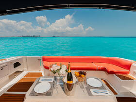 A beautifully set dining area on a boat featuring champagne, fresh fruit, and elegant tableware, perfect for a luxurious day on the water.