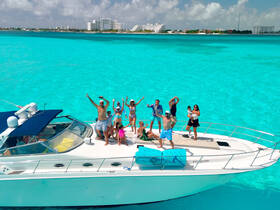 A lively group celebrates on a yacht in stunning turquoise waters, perfect for unforgettable boat parties and family fun.