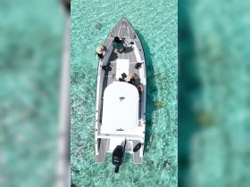 Aerial view of a group of people aboard a boat in crystal-clear waters, showcasing a perfect day for exploration and adventure on the water.