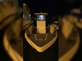 A clear view of a boat's exterior at night, showcasing its sleek design and structure while docked at the marina.