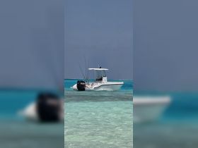 A sleek speedboat anchored in crystal-clear waters, perfect for fishing adventures or leisurely outings on the water.