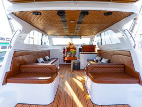 A beautifully designed interior of a boat featuring comfortable seating and a well-organized helm area, perfect for relaxing during a day on the water.