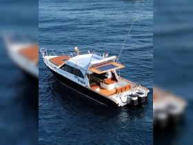 A stunning aerial view of a sleek boat cruising through clear waters, showcasing its elegant design and fishing gear — perfect for a day on the water.