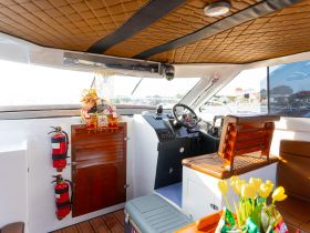 A well-appointed helm area inside a boat, featuring comfortable seating and essential controls, ideal for navigating the waters in style.